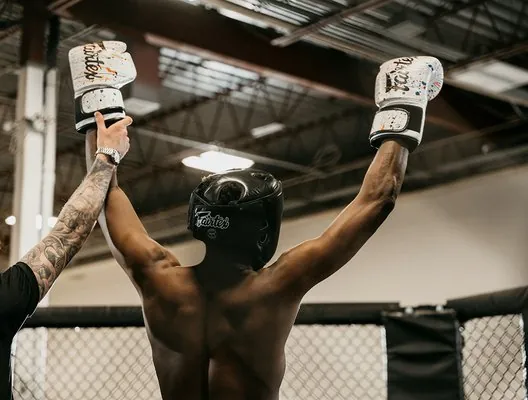 A fighter's arms raised inside the cage